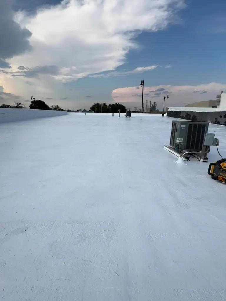 Flat commercial roof coated with white elastomeric coating